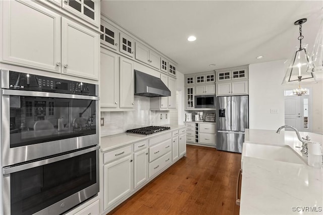 6636 Stonewolf Ct, Moseley, VA 23120 - kitchen with stainless steel appliances, wall chimney range hood, tasteful backsplash, white cabinetry, and recessed lighting