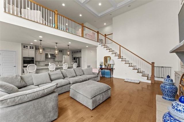 6636 Stonewolf Ct, Moseley, VA 23120 - living room featuring a towering ceiling, light wood-style floors, recessed lighting, stairs, and a fireplace with raised hearth