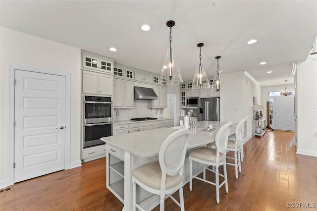6636 Stonewolf Ct, Moseley, VA 23120 - kitchen with wall chimney range hood, a chandelier, stainless steel appliances, light countertops, and recessed lighting
