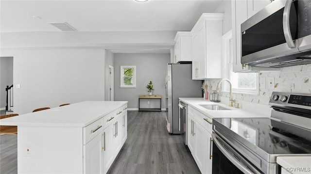 1531 Berkeley Ave, Petersburg, VA 23805 - kitchen featuring appliances with stainless steel finishes, a center island, decorative backsplash, and white cabinets