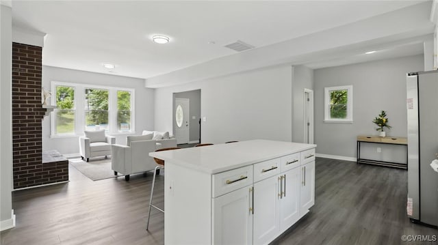 1531 Berkeley Ave, Petersburg, VA 23805 - kitchen with freestanding refrigerator, dark wood-style flooring, open floor plan, white cabinetry, and a breakfast bar