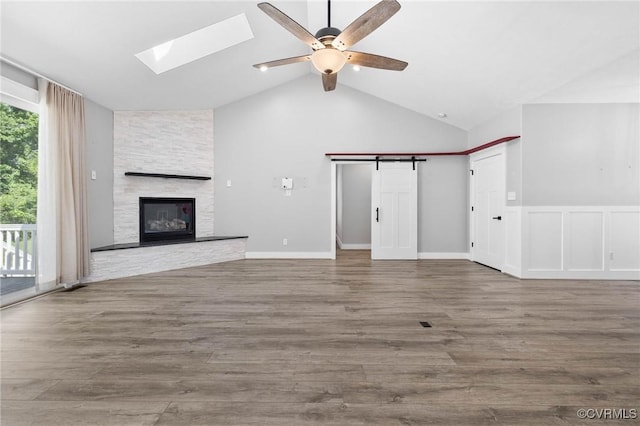3130 Tinsley Ter, Prince George, VA 23875 - unfurnished living room with a ceiling fan, lofted ceiling, a skylight, a stone fireplace, and wood finished floors