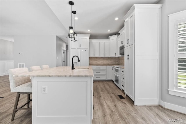 3130 Tinsley Ter, Prince George, VA 23875 - kitchen featuring white appliances, healthy amount of natural light, a breakfast bar area, decorative backsplash, and recessed lighting