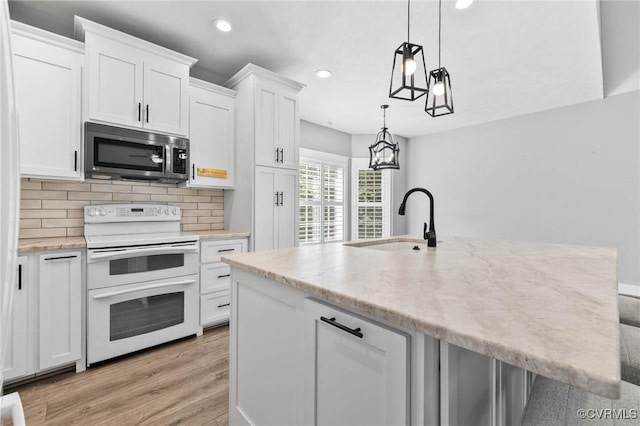 3130 Tinsley Ter, Prince George, VA 23875 - kitchen featuring double oven range, stainless steel microwave, white cabinetry, recessed lighting, and backsplash