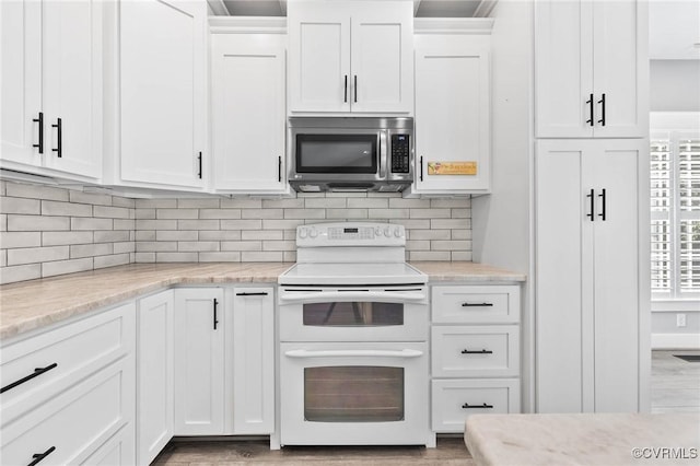 3130 Tinsley Ter, Prince George, VA 23875 - kitchen with stainless steel microwave, double oven range, white cabinetry, and tasteful backsplash