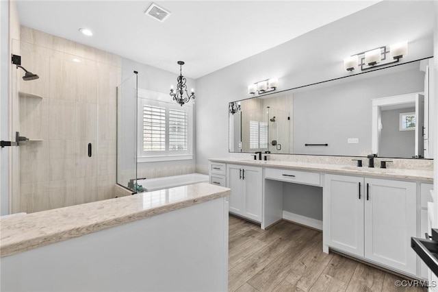 3130 Tinsley Ter, Prince George, VA 23875 - full bathroom featuring a shower stall, double vanity, a garden tub, wood finished floors, and a chandelier