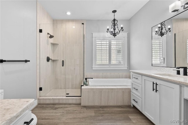 3130 Tinsley Ter, Prince George, VA 23875 - bathroom featuring a chandelier, vanity, a bath, a shower stall, and wood finished floors