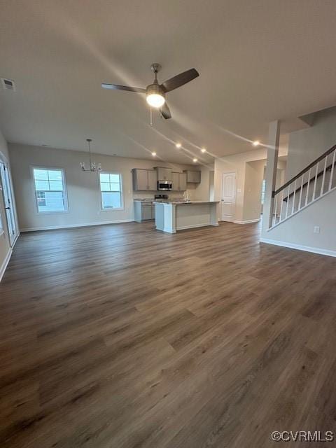 7079 Hepworth Dr, Henrico, VA 23231 - unfurnished living room featuring dark wood finished floors, ceiling fan, a chandelier, and stairs