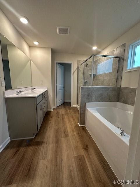 7079 Hepworth Dr, Henrico, VA 23231 - full bathroom featuring a garden tub, double vanity, a shower stall, wood finished floors, and recessed lighting