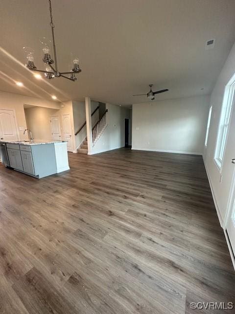 7079 Hepworth Dr, Henrico, VA 23231 - unfurnished living room with a chandelier, stairs, dark wood-style floors, and ceiling fan