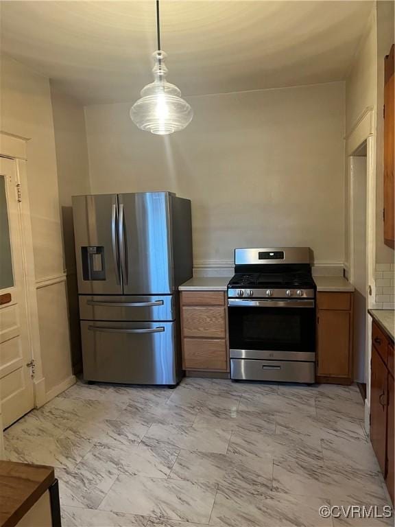 817 Lafayette Ave, Colonial Heights, VA 23834 - kitchen featuring appliances with stainless steel finishes, light marble finish flooring, light countertops, brown cabinetry, and hanging light fixtures