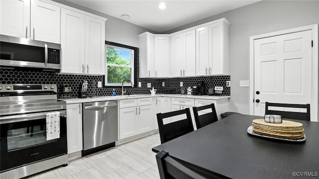 1323 Avondale Ave, Richmond, VA 23227 - kitchen with appliances with stainless steel finishes, decorative backsplash, white cabinets, and light countertops