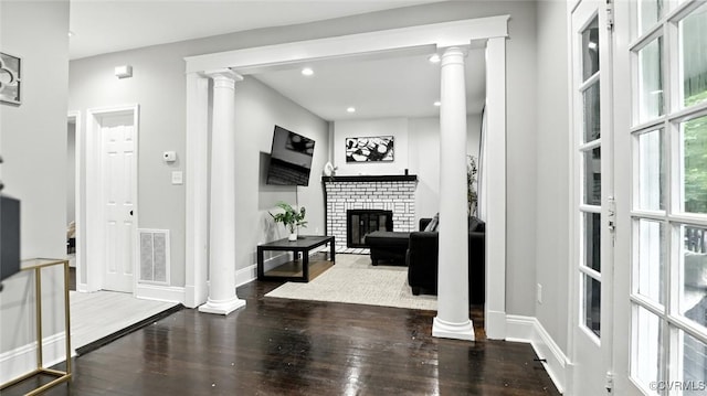 1323 Avondale Ave, Richmond, VA 23227 - living room with ornate columns, wood finished floors, a brick fireplace, and recessed lighting