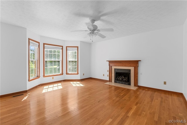 6768 Poplar Woods Ct, Quinton, VA 23141 - unfurnished living room with light wood-style floors, ceiling fan, a fireplace with flush hearth, and a textured ceiling