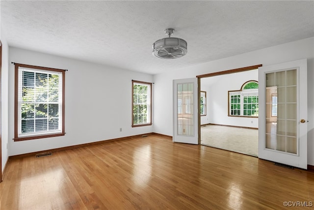 6768 Poplar Woods Ct, Quinton, VA 23141 - unfurnished room with french doors, wood finished floors, and a textured ceiling