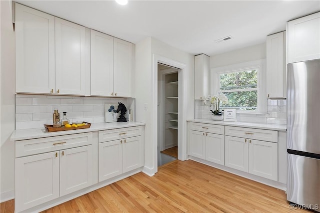 4029 Old Buckingham Rd, Powhatan, VA 23139 - kitchen with freestanding refrigerator, backsplash, light wood-style floors, and light countertops
