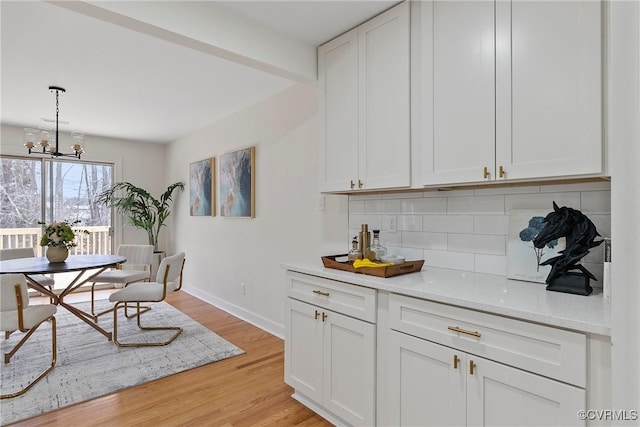 4029 Old Buckingham Rd, Powhatan, VA 23139 - kitchen featuring tasteful backsplash, light wood-type flooring, white cabinets, decorative light fixtures, and a chandelier