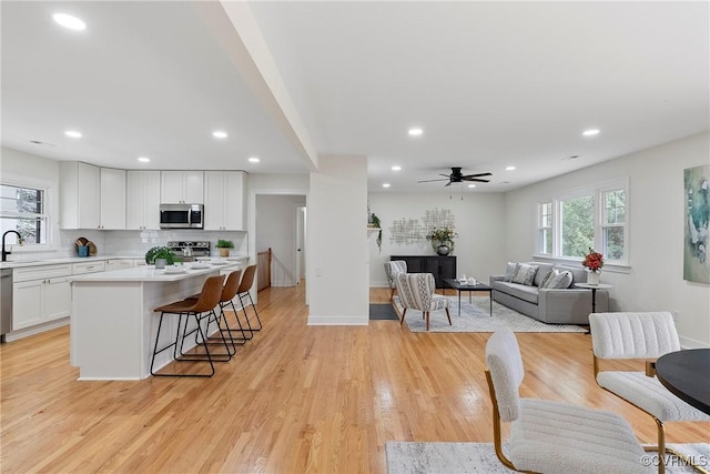 4029 Old Buckingham Rd, Powhatan, VA 23139 - kitchen with appliances with stainless steel finishes, white cabinetry, light countertops, a breakfast bar, and open floor plan