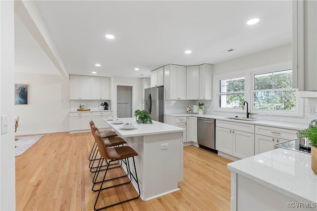 4029 Old Buckingham Rd, Powhatan, VA 23139 - kitchen featuring appliances with stainless steel finishes, tasteful backsplash, a kitchen bar, a kitchen island, and recessed lighting