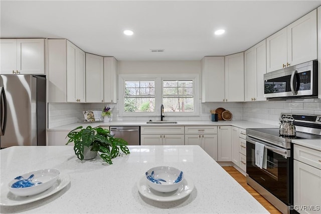 4029 Old Buckingham Rd, Powhatan, VA 23139 - kitchen featuring appliances with stainless steel finishes, light stone counters, white cabinets, and recessed lighting