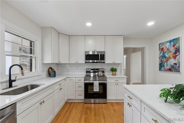 4029 Old Buckingham Rd, Powhatan, VA 23139 - kitchen featuring stainless steel appliances, tasteful backsplash, white cabinets, recessed lighting, and light wood-style flooring