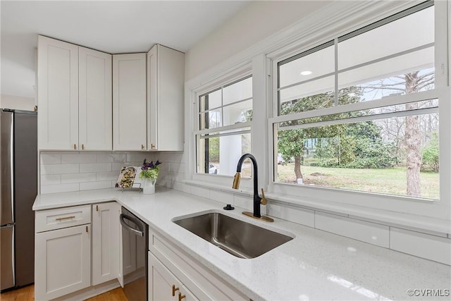 4029 Old Buckingham Rd, Powhatan, VA 23139 - kitchen with stainless steel appliances, white cabinetry, light stone counters, and backsplash