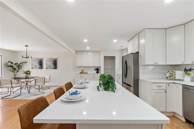 4029 Old Buckingham Rd, Powhatan, VA 23139 - kitchen featuring stainless steel appliances, light wood finished floors, recessed lighting, tasteful backsplash, and white cabinets