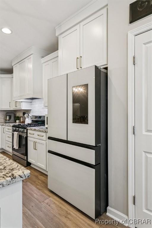 4217 Pillar, Williamsburg, VA 23188 - kitchen with freestanding refrigerator, stainless steel range with gas stovetop, white cabinets, recessed lighting, and backsplash