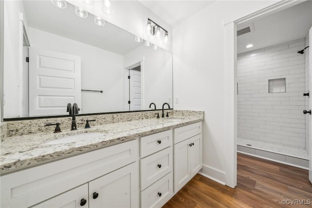 2467 Judes Ferry Rd, Powhatan, VA 23139 - bathroom with double vanity, a tile shower, and wood finished floors