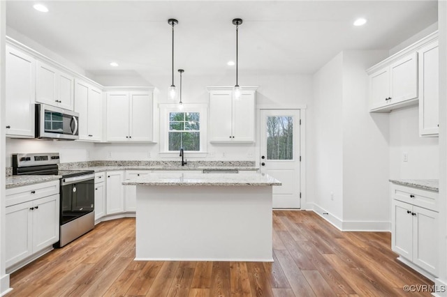 2467 Judes Ferry Rd, Powhatan, VA 23139 - kitchen with stainless steel appliances, light wood finished floors, white cabinets, a kitchen island, and recessed lighting