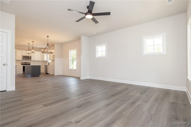 706 S Main St, Blackstone, VA 22824 - unfurnished living room featuring a chandelier, wood finished floors, and a ceiling fan