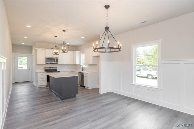 706 S Main St, Blackstone, VA 22824 - kitchen featuring stainless steel appliances, a chandelier, a decorative wall, light countertops, and plenty of natural light