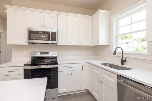 706 S Main St, Blackstone, VA 22824 - kitchen with appliances with stainless steel finishes, light countertops, white cabinetry, and wood finished floors