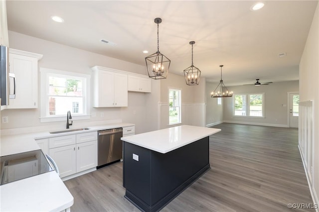706 S Main St, Blackstone, VA 22824 - kitchen with stainless steel dishwasher, a center island, wood finished floors, white cabinets, and recessed lighting