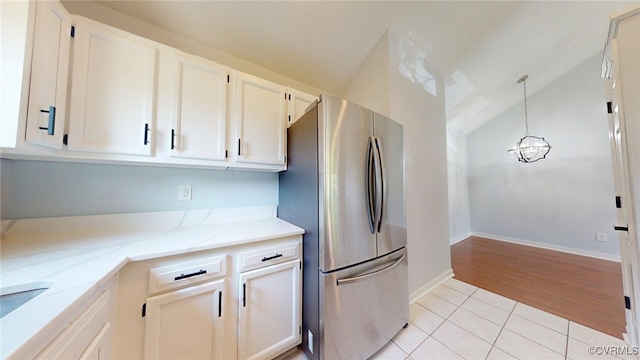 7816 Camolin Ct, Henrico, VA 23228 - kitchen featuring freestanding refrigerator, vaulted ceiling, light stone countertops, light tile patterned floors, and hanging light fixtures