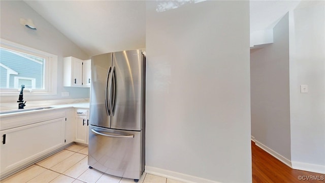 7816 Camolin Ct, Henrico, VA 23228 - kitchen featuring freestanding refrigerator, white cabinets, vaulted ceiling, and light countertops