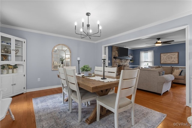 5307 Dermotte Ln, North Chesterfield, VA 23237 - dining space featuring a chandelier, wood finished floors, a stone fireplace, ornamental molding, and a ceiling fan