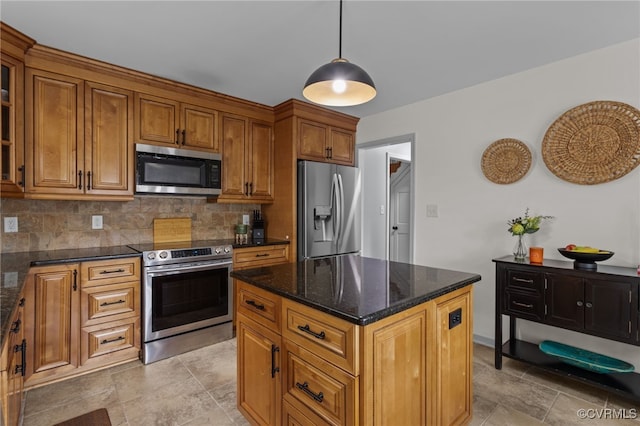 5307 Dermotte Ln, North Chesterfield, VA 23237 - kitchen featuring stainless steel appliances, decorative backsplash, brown cabinetry, dark stone counters, and a center island