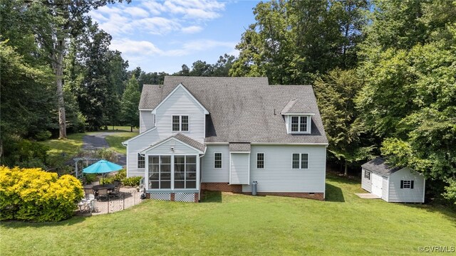1638 Olde Links Dr, Powhatan, VA 23139 - rear view of house with a sunroom, a lawn, a shingled roof, a storage shed, and a patio area