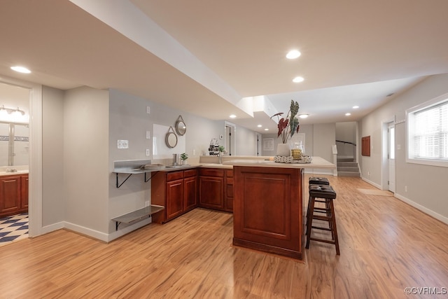 10801 Cherry Hill Dr, Glen Allen, VA 23059 - kitchen with light wood-style flooring, a breakfast bar, recessed lighting, light countertops, and a peninsula