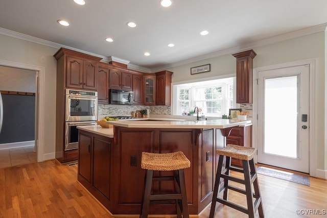 10801 Cherry Hill Dr, Glen Allen, VA 23059 - kitchen with double oven, black microwave, light countertops, a breakfast bar area, and decorative backsplash