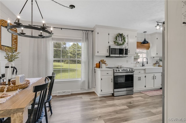 453 Manquin Dr, King William, VA 23009 - kitchen with appliances with stainless steel finishes, a chandelier, light countertops, and light wood-style floors