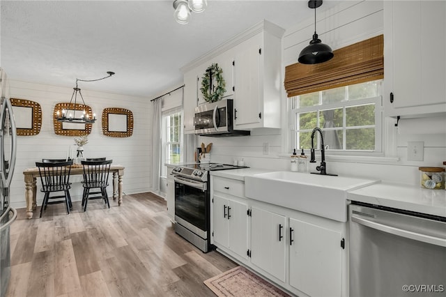 453 Manquin Dr, King William, VA 23009 - kitchen with appliances with stainless steel finishes, white cabinetry, light countertops, light wood-style flooring, and decorative light fixtures