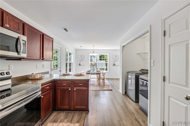 4107 Forest Vine Pl, Chesterfield, VA 23834 - kitchen featuring appliances with stainless steel finishes, washing machine and dryer, reddish brown cabinets, a peninsula, and wood finished floors