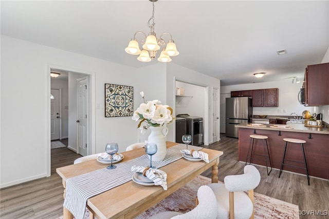 4107 Forest Vine Pl, Chesterfield, VA 23834 - dining area featuring washer and clothes dryer, a chandelier, and light wood-style floors