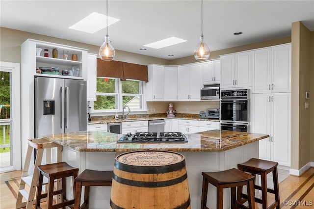 10598 Lambeth Rd, Glen Allen, VA 23060 - kitchen with a skylight, appliances with stainless steel finishes, white cabinetry, decorative light fixtures, and recessed lighting