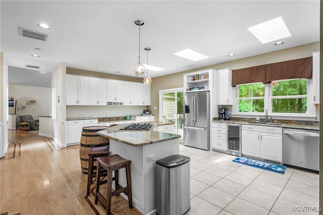 10598 Lambeth Rd, Glen Allen, VA 23060 - kitchen featuring stainless steel appliances, wine cooler, plenty of natural light, a skylight, and recessed lighting