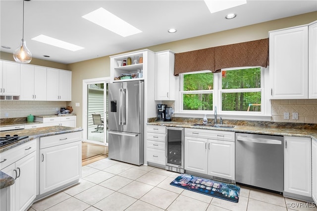 10598 Lambeth Rd, Glen Allen, VA 23060 - kitchen featuring stainless steel appliances, wine cooler, a skylight, white cabinets, and recessed lighting