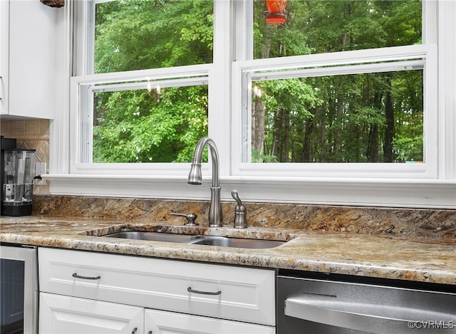 10598 Lambeth Rd, Glen Allen, VA 23060 - kitchen view of wine cooler, stainless steel dishwasher, white cabinetry, and backsplash