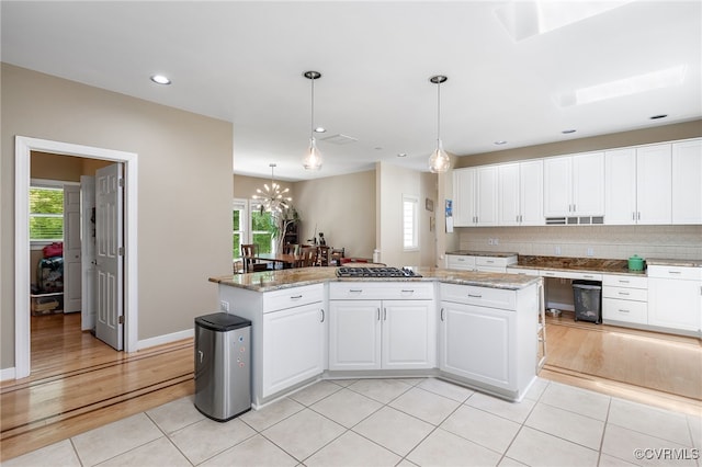 10598 Lambeth Rd, Glen Allen, VA 23060 - kitchen with stainless steel gas stovetop, light tile patterned floors, a chandelier, white cabinetry, and recessed lighting
